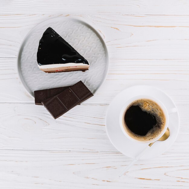 Top view of tea; delicious pastry with chocolate bar for breakfast on table