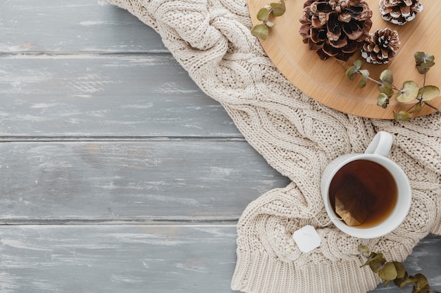 Free photo top view tea mugand pine cones with pullover