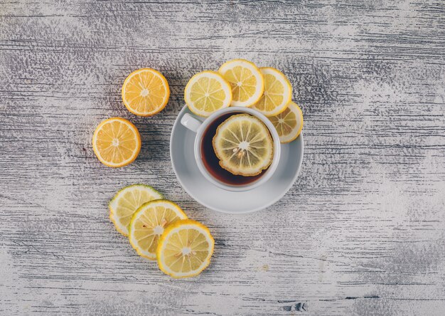 Top view tea with lemon slices on gray wooden background. horizontal