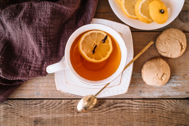 Top view tea with slices of lemon and cookies