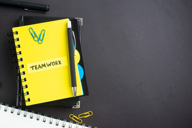 top view teamwork note with notepads on dark background