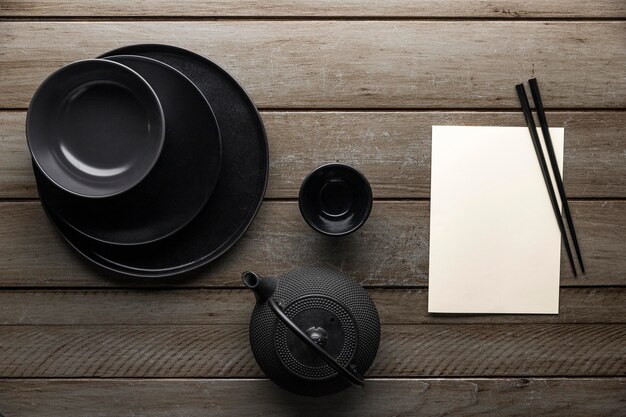 Top view of teapot with dishware and chopsticks