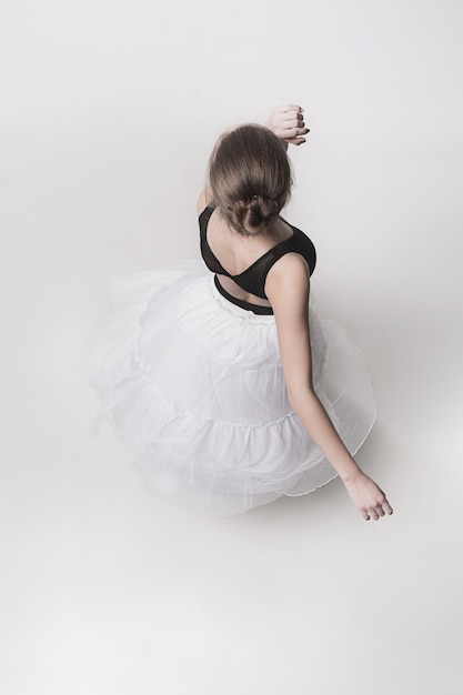 The top view of the teen ballerina on white studio background