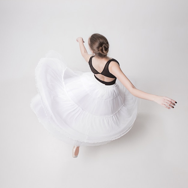 Вид сверху на балерину-подростка на белом