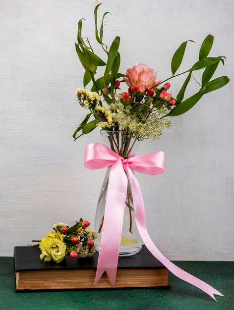 Top view of tender and lovely flowers with leaves on a glass vase on white surface