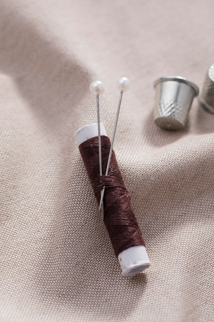 Top view of thread reel with needles and thimbles