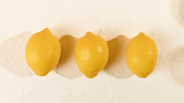 Top view three fresh lemons aligned on table