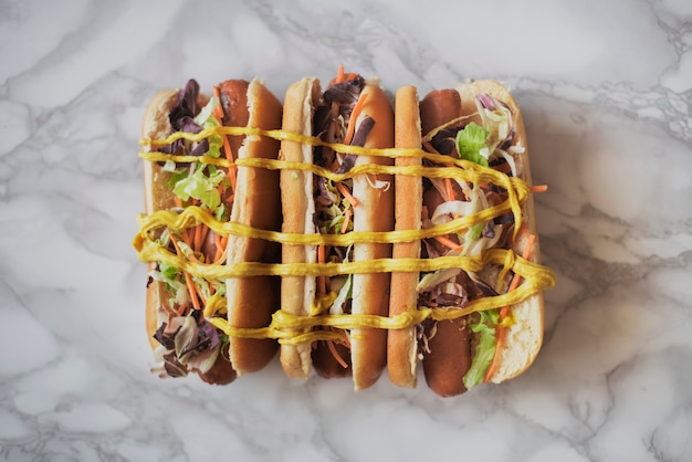 Foto gratuita vista dall'alto tre hot dog con senape