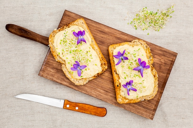 Вид сверху тост с цветами на разделочную доску