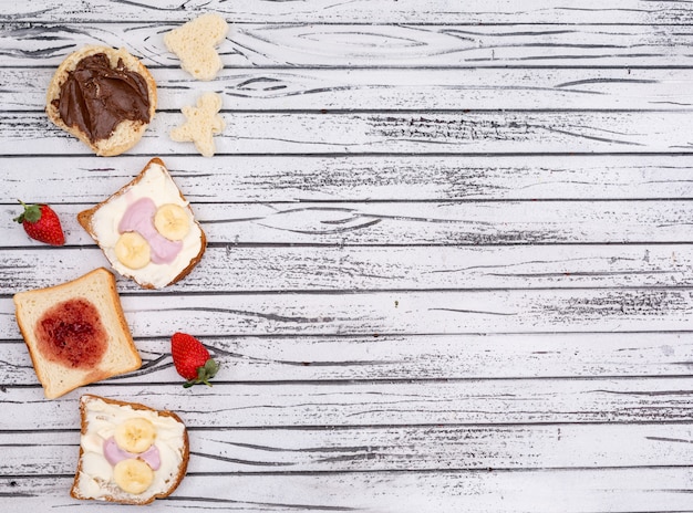 Вид сверху тосты с вареньем, йогуртом и копией пространства на белом фоне деревянные горизонтальные