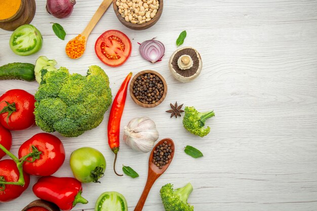 Top view tomato branch broccoli bell pepper anise black pepper in bowl on grey background