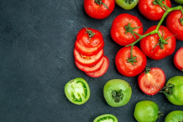 Free photo top view tomato branch chopped tomatoes fresh green tomatoes on black table