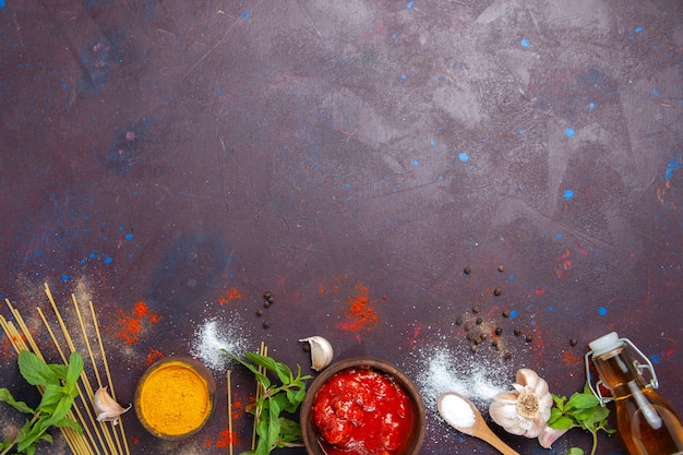 Foto gratuita vista dall'alto salsa di pomodoro con condimenti su sfondo scuro pasto salsa piccante