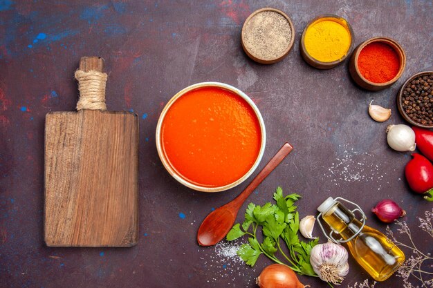 Top view of tomato soup cooked from fresh tomatoes with seasonings on black