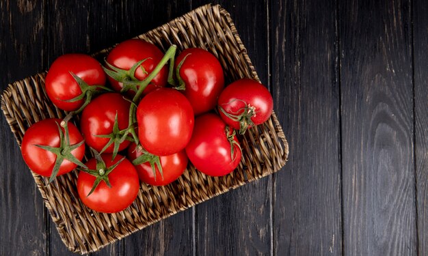 Top view of tomatoes in basket plate on wood with copy space