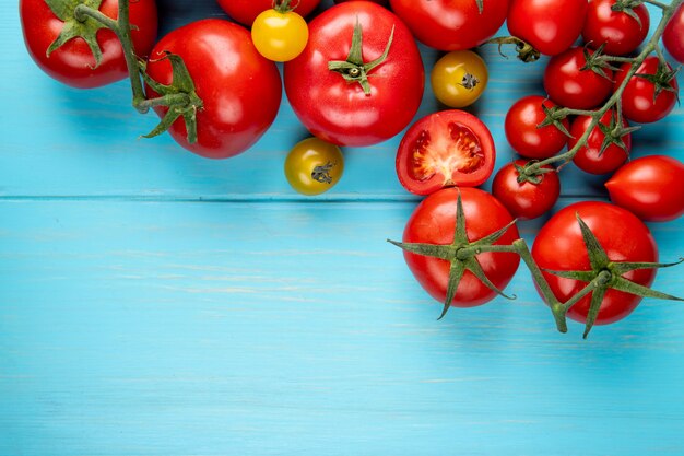 Top view of tomatoes on blue surface with copy space