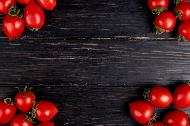 Top view of tomatoes on left and right sides and wood with copy space