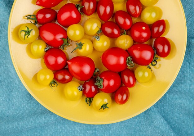 Foto gratuita vista dall'alto di pomodori nel piatto sul panno blu
