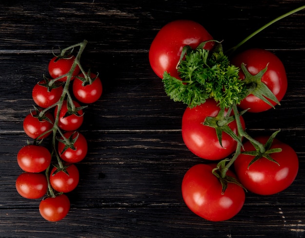 Top view of tomatoes with coriander on wooden surface