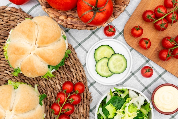 Top view of tomatoes with sandwiches and salad