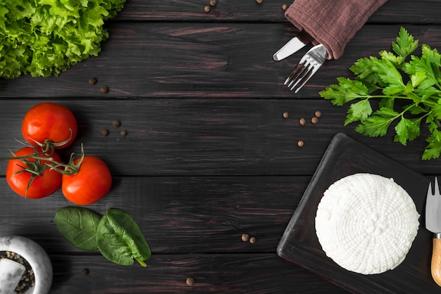 Foto gratuita vista dall'alto di pomodori con spinaci e posate