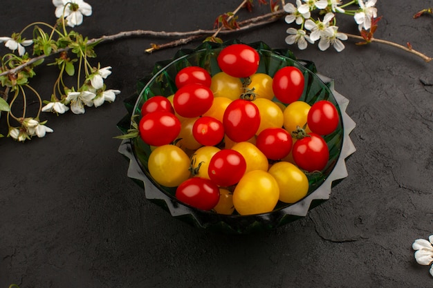 top view tomatoes yellow red inside green plate on the dark floor