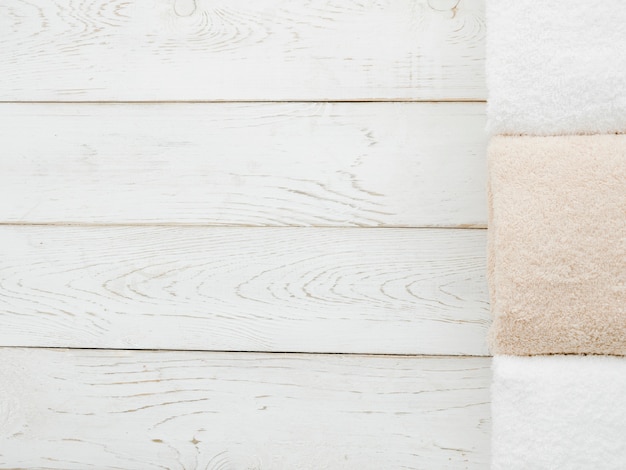 Free photo top view towels on wooden background with copyspace