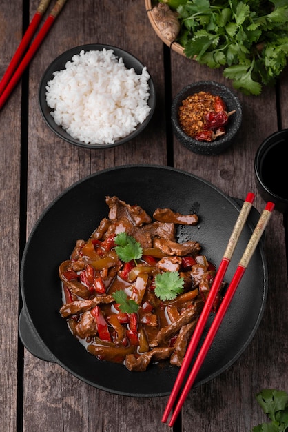 Top view of traditional asian dish with chopsticks and rice