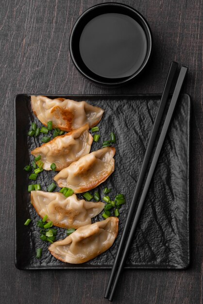 Top view of traditional asian dumplings on slate with chopsticks