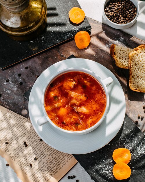 Top view of traditional russian cabbage soup with meat in a white bowl