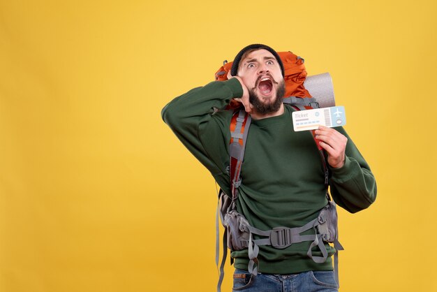 Top view of travel concept with nervous emotional young guy with packpack and calling someone