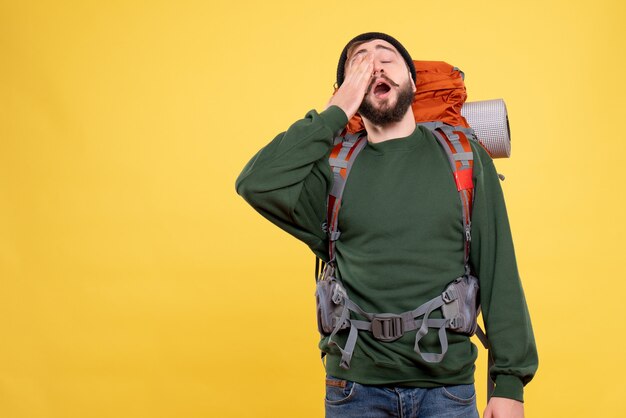 Top view of travel concept with sleepy young guy with packpack