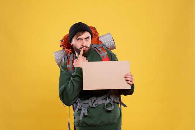 Top view of travel concept with thinking young guy with packpack and holding free space for writing