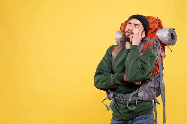 Top view of travel concept with thinking young guy with packpack