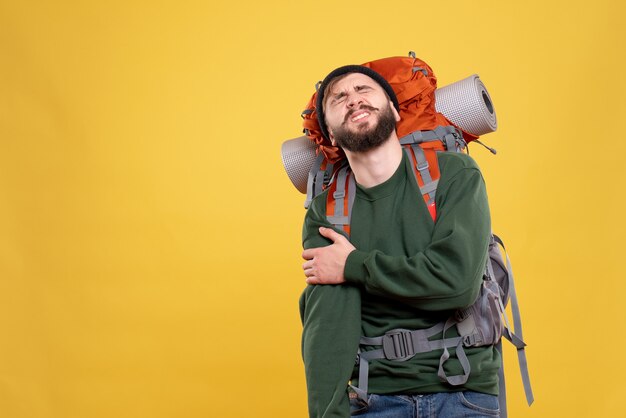 Top view of travel concept with troubled young guy with packpack suffering from shoulder pain