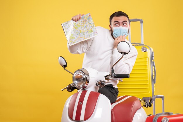オートバイの近くに立っている医療用マスクの若い男との旅行のコンセプトのトップ ビュー