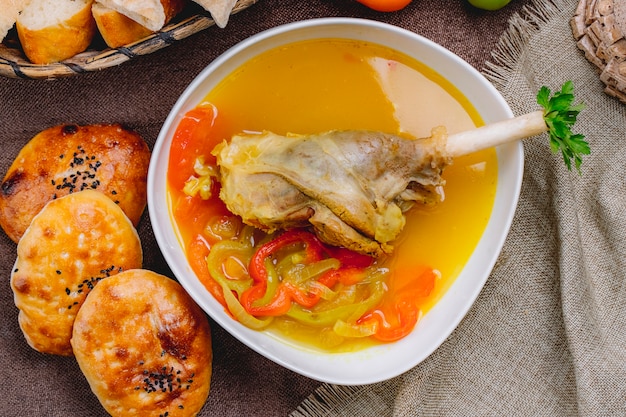 Top view turkey leg soup with bell pepper and bread