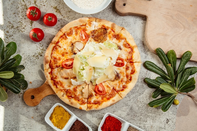 Top view of turkey pizza topped with lettuce salad and parmesan