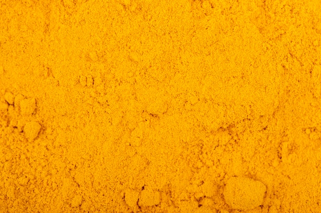 Top view of turmeric powder background and texture