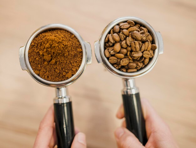 Top view of two coffee machine cups held by barista