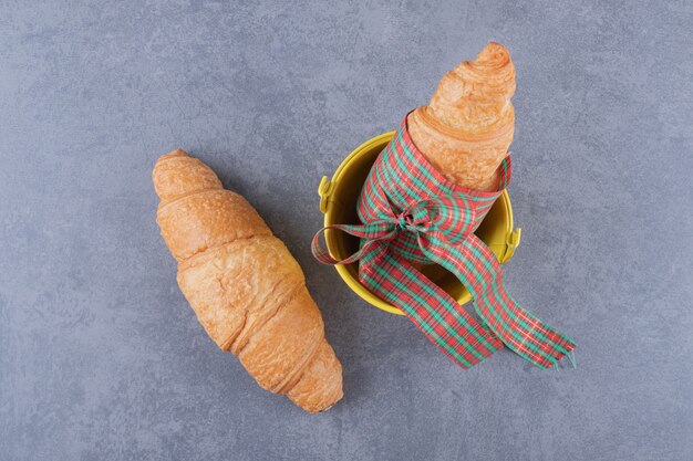 Foto gratuita vista dall'alto di due croissant su sfondo grigio.