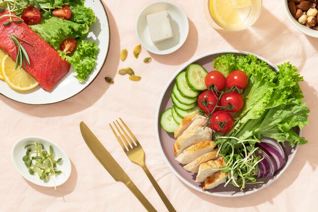 Top view of two plates with keto diet food and golden fork and knife