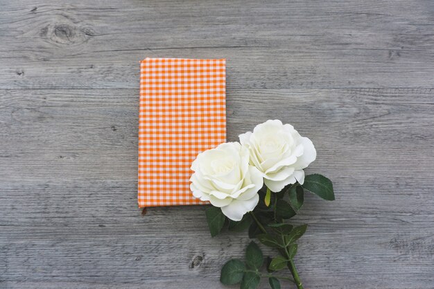 Top view of two white flowers on a book