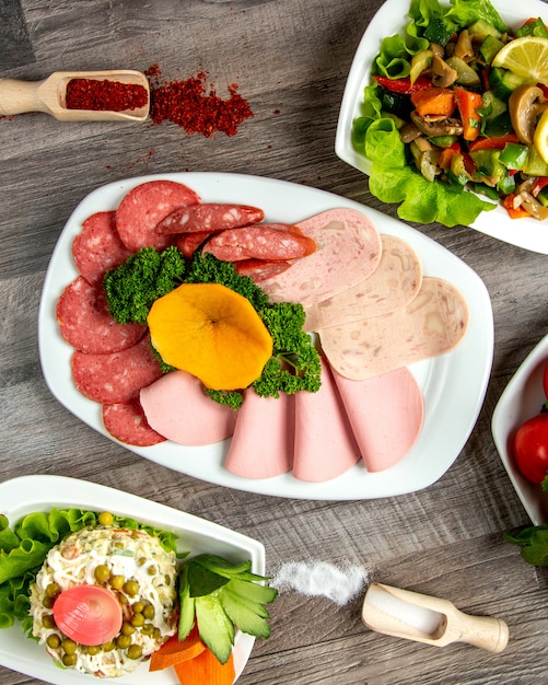 Top view a type of sausage on a plate with herbs and spices on the table