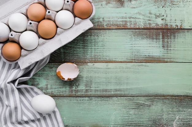 Free photo top view of uncolored eggs in carton for easter