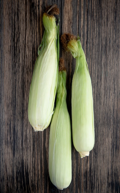 Free photo top view of uncooked corns on wood