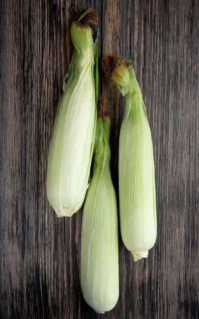 Top view of uncooked corns on wooden surface 1