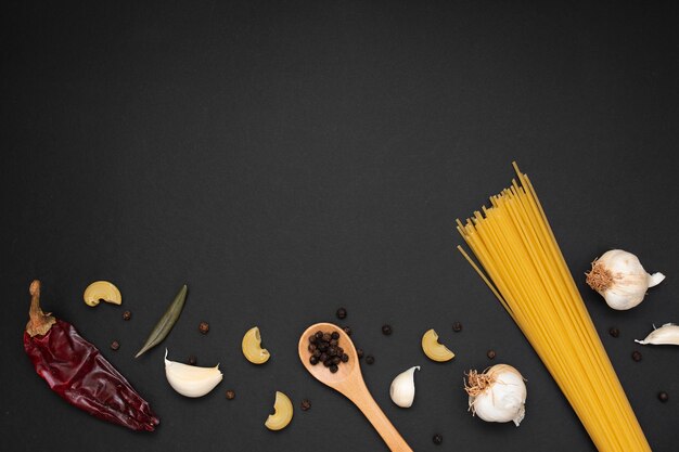 Top view uncooked pasta with wooden spoon ingredients and copy space