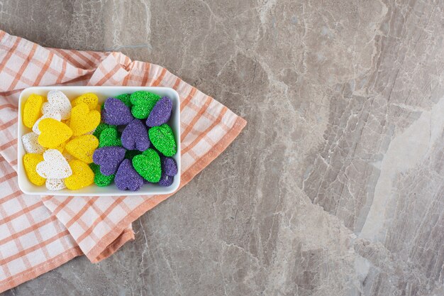 Top view of valentine candies in heart shape inside white bowl.