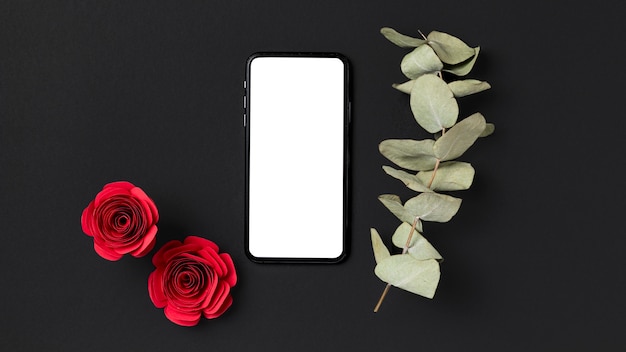 Free photo top view of valentine's day roses with smartphone and plant